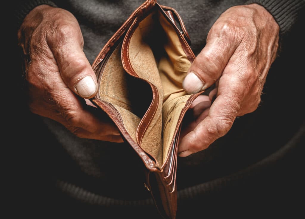 Empty wallet in the hands of an older man